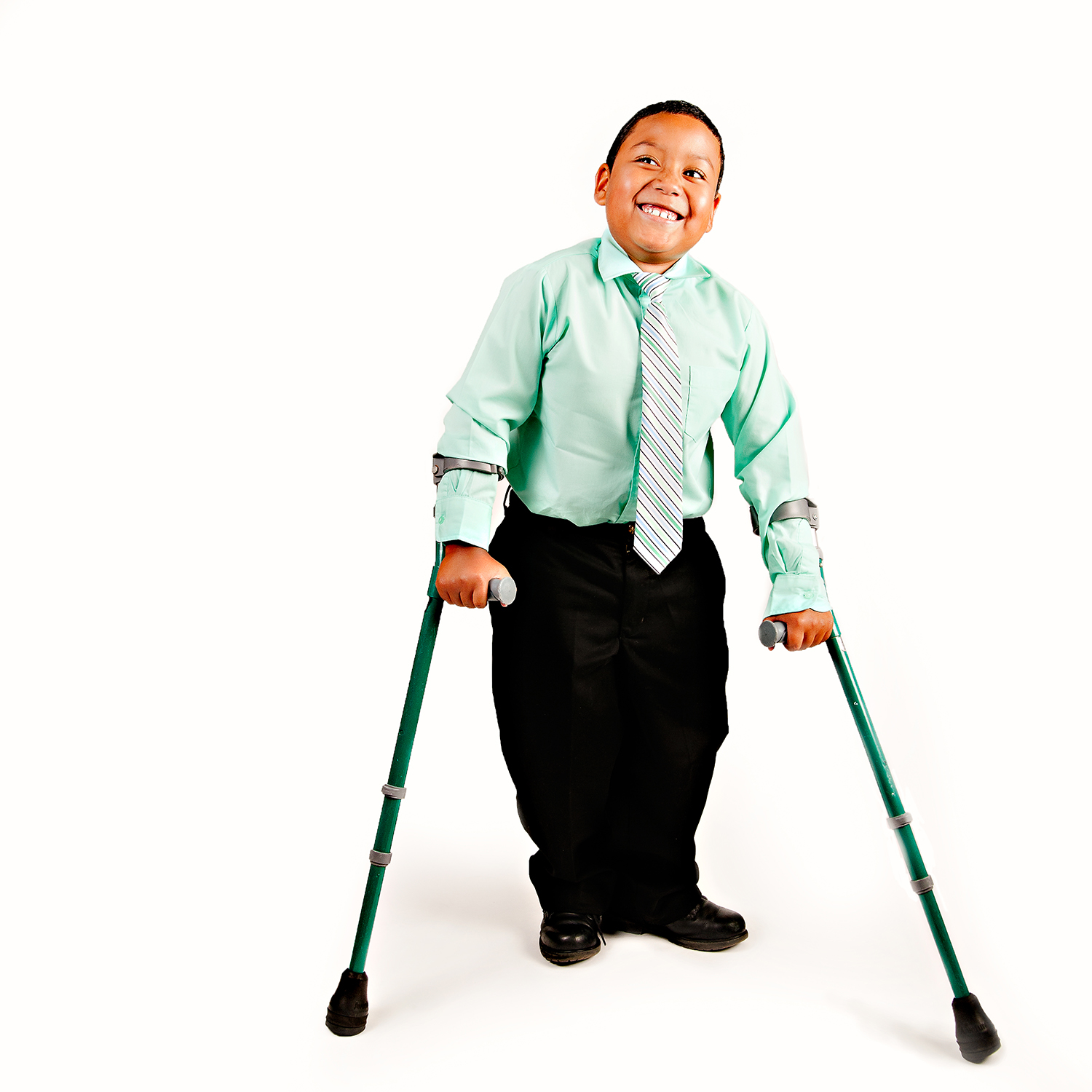 A smiling boy wearing a green shirt and tie