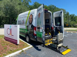 Accessible van parked next to CIL sign in parking lot. The van is about to lift a power chair.